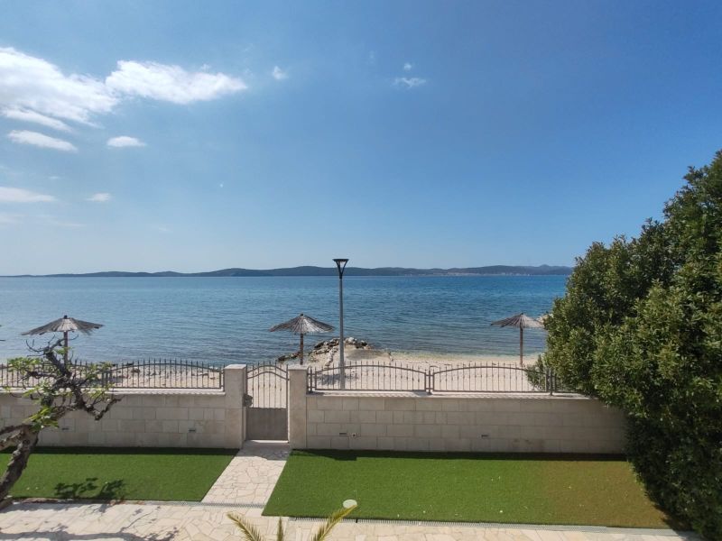 Meerblick und Terrasse bei einem Einfamilienhaus in Bibinje mit Strandsonnenschirmen.