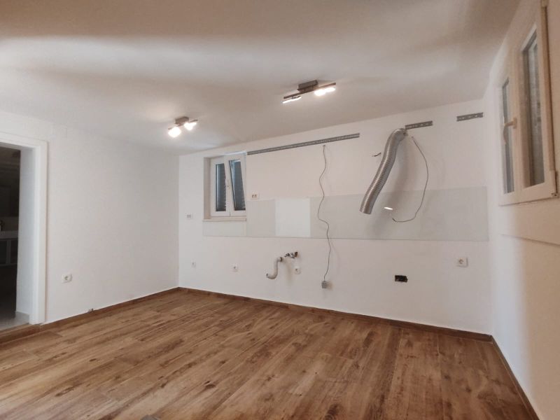 Eine leere Küche in einem Einfamilienhaus mit einem Holzboden.