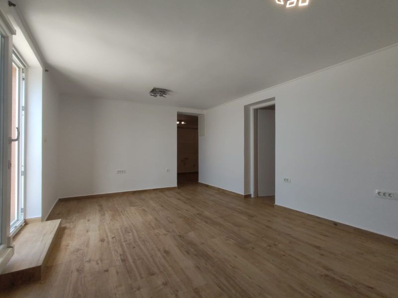 Ein großer, heller Raum in einem Einfamilienhaus mit einem Holzboden.