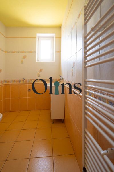 Ein Badezimmer in einem Einfamilienhaus mit gelben Wänden und einem weißen Heizkörper.