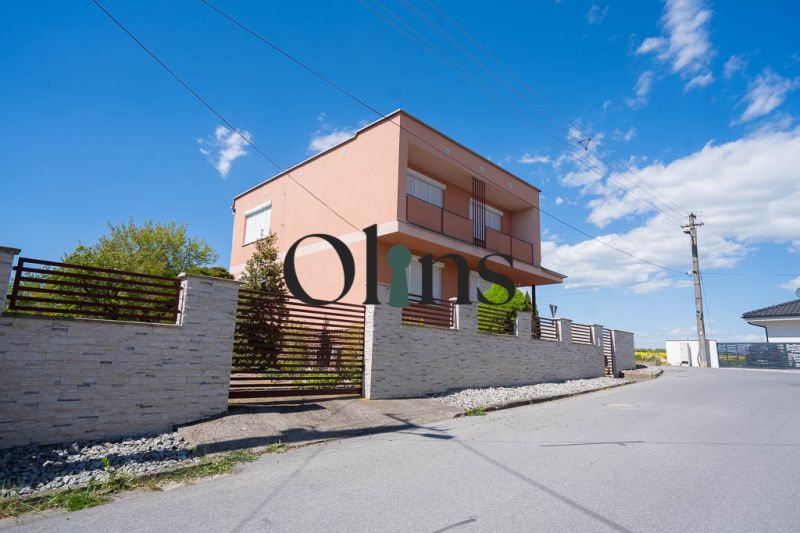 Ein Einfamilienhaus in der B. Tablica Straße in Dudince mit einer Steinmauer und blauem Himmel.