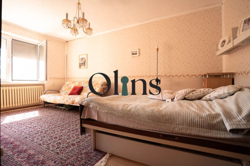 Schlafzimmer in einem Einfamilienhaus mit Teppich, Bett, Sofa und Kronleuchter.