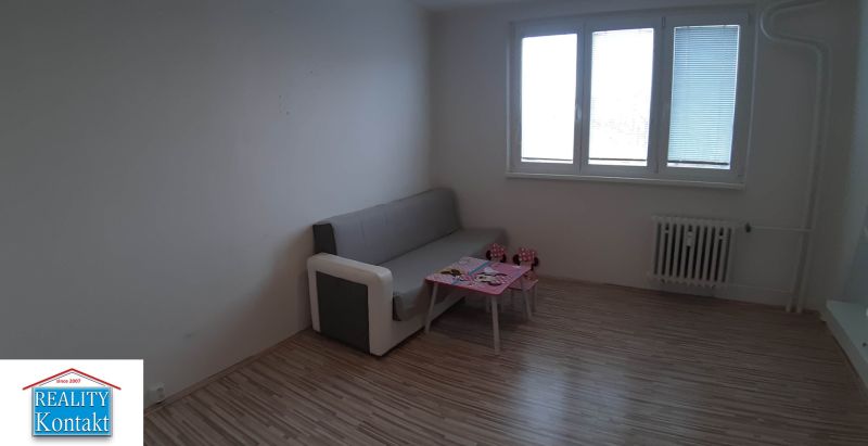 Wohnzimmer in einer Zweizimmerwohnung mit Sofa und Tisch, Boden mit Holzdekor.