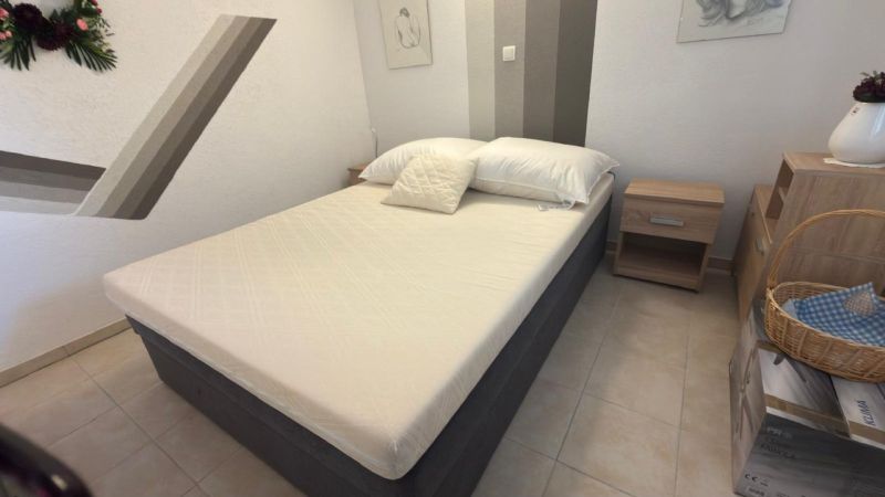 Schlafzimmer in einem Einfamilienhaus mit einem einfachen Bett und Nachttischen.