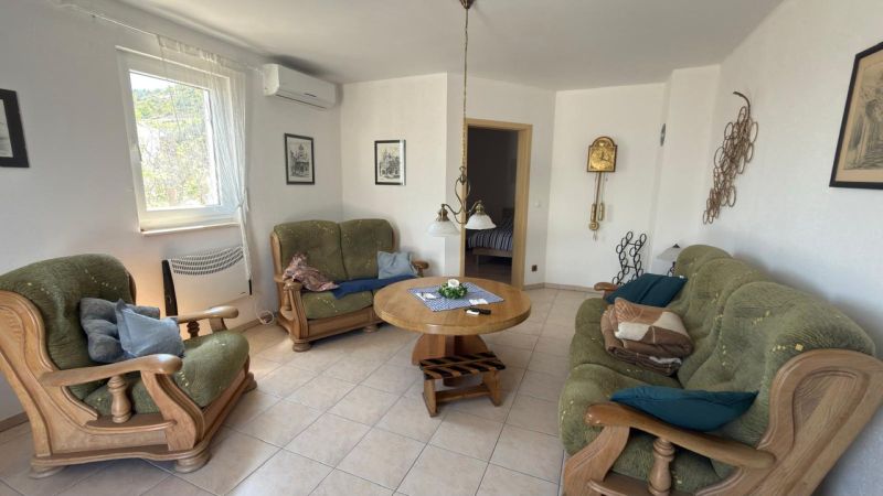 Wohnzimmer in einem Einfamilienhaus mit Sofa und Holzmöbeln.
