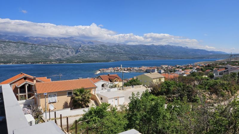 Blick auf die Küste und ein Familienhaus in der Stadt Vinjerac mit Bergen im Hintergrund.
