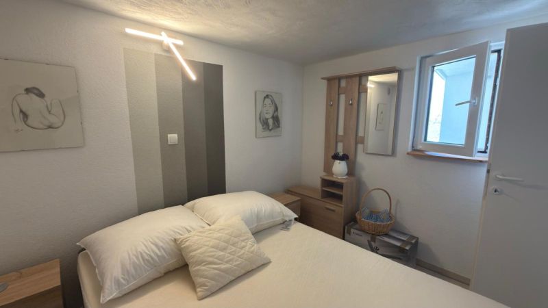 Schlafzimmer im Einfamilienhaus mit dekorativer Beleuchtung und Bildern an den Wänden.