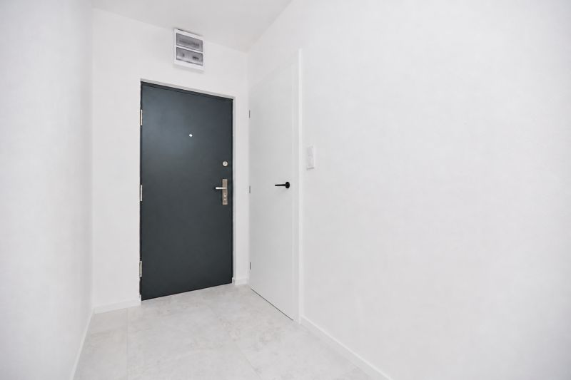 Eingangsflur mit grauen Türen und weißen Wänden in einer 3-Zimmer-Wohnung.