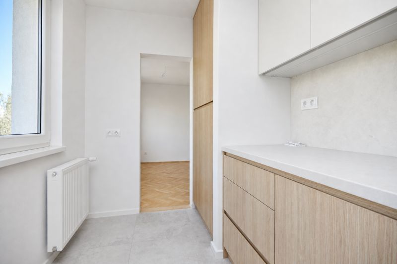Küche mit Schränken und Blick auf den Boden mit Holzdekor in einer 3-Zimmer-Wohnung.