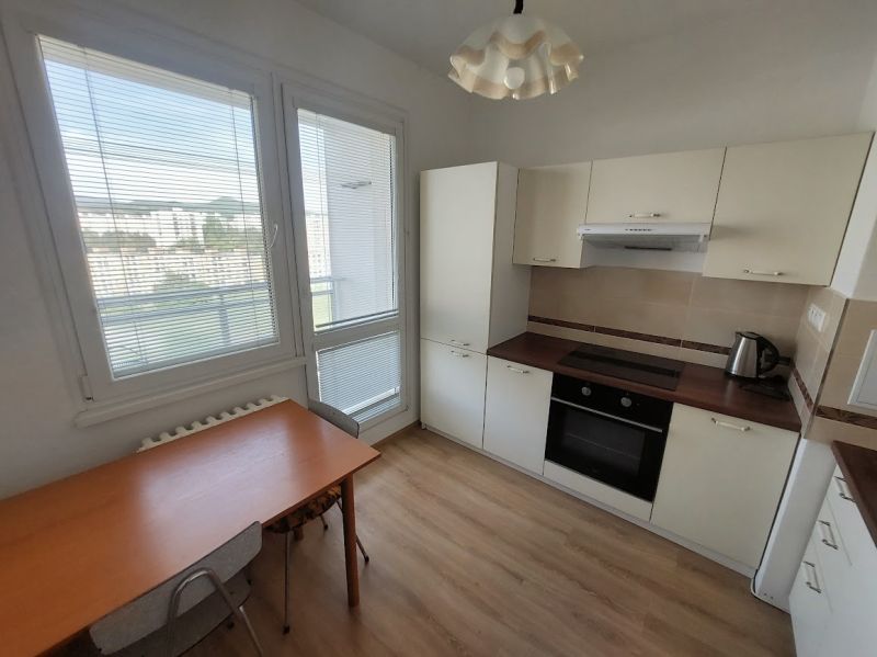 Küche in einer Einzimmerwohnung mit Holzboden und Esstisch.