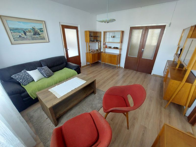 Wohnzimmer in einer Einzimmerwohnung mit Holzboden und Retro-Möbeln.