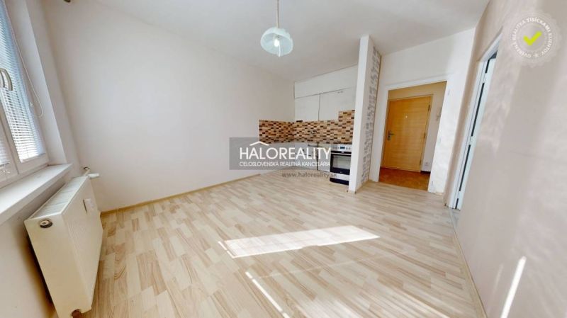 Küche in einer Einzimmerwohnung mit Holzboden und Keramikfliesen.