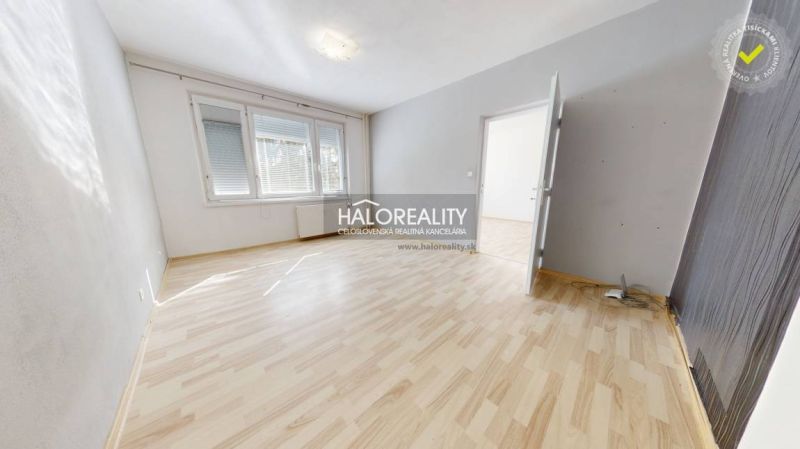 Helles Zimmer mit Holzboden in einer Einzimmerwohnung.