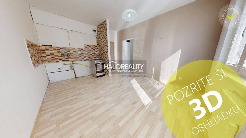 Ein Zimmer mit Holzboden und einer Kochnische in einer Einzimmerwohnung.