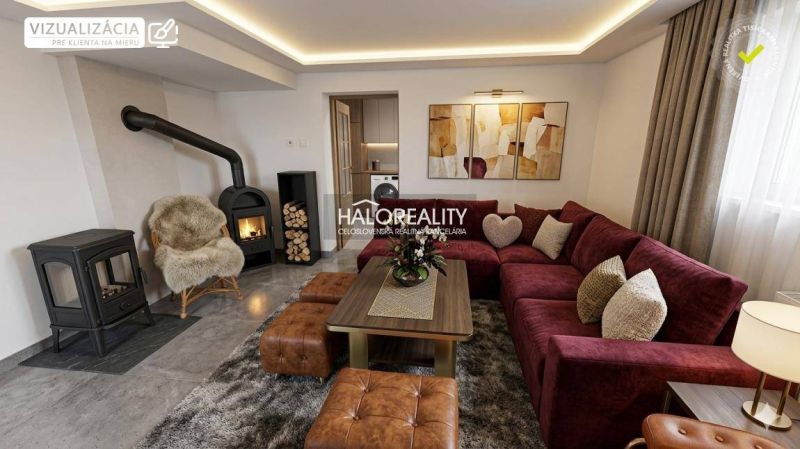 Wohnzimmer in einem Einfamilienhaus mit Kamin, weinrotem Sofa und gemütlicher Dekoration.