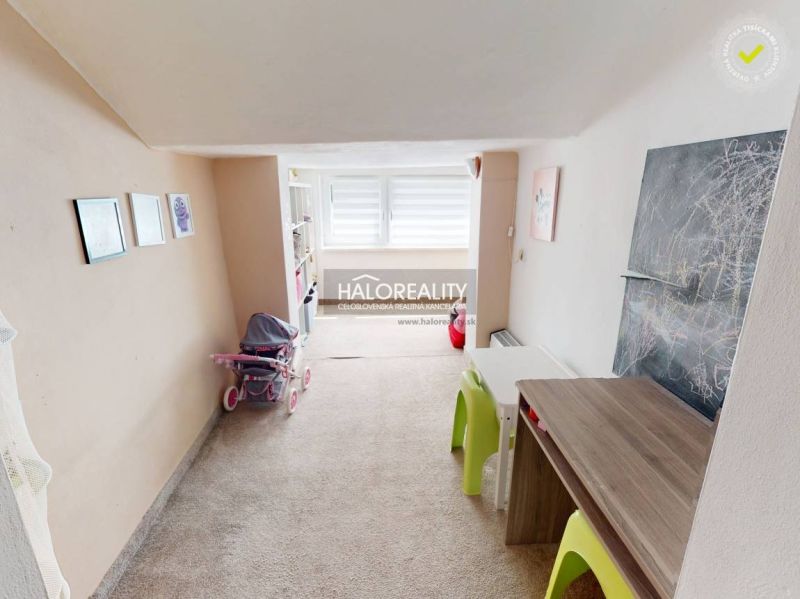 Kinderzimmer in einem Einfamilienhaus mit Teppich, Möbeln und Kinderzeichnungen.