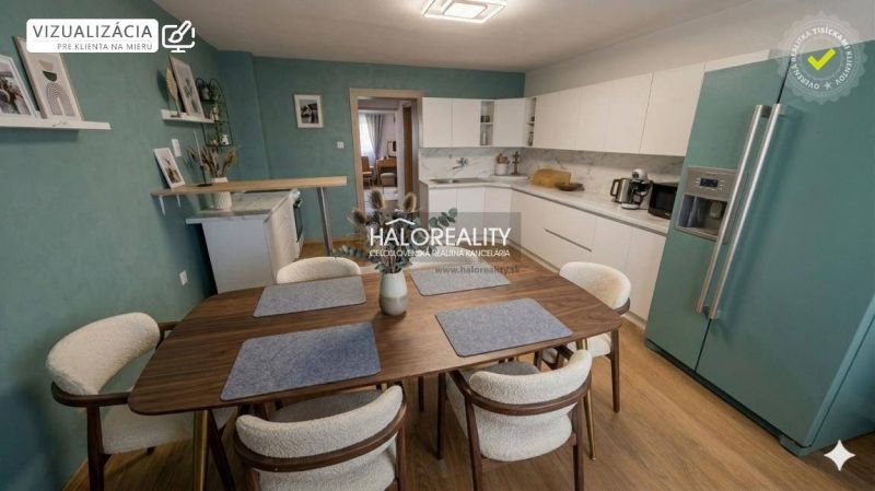 Küche in einem Einfamilienhaus mit weißen Schränken, Holzboden und Esstisch.