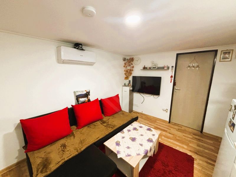 Wohnzimmer in einer Hütte mit Holzboden und roten Accessoires.