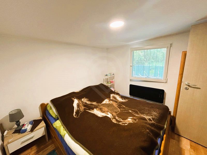 Eine Hütte mit Holzboden, Bett und Nachttisch, einfaches Schlafzimmerdesign.