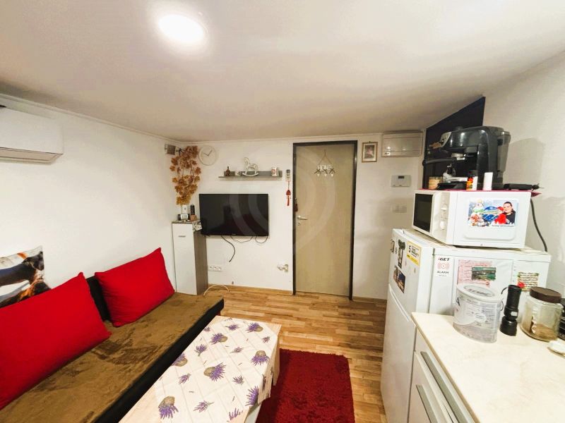 Wohnzimmer in einer Hütte mit Holzboden und roten Elementen.