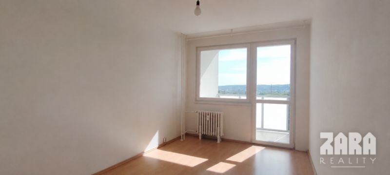 Ein Zimmer mit einem Holzboden und einem großen Fenster in einer 4-Zimmer-Wohnung.