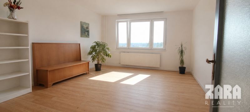 Wohnzimmer mit hellem Boden in Holzoptik und Pflanzen in einer Vierzimmerwohnung.