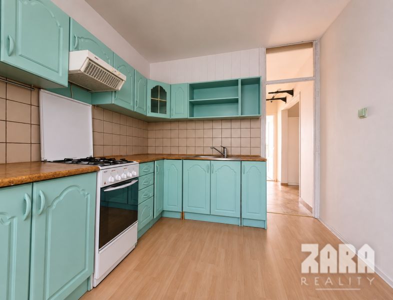 Eine Küche mit türkisfarbenen Schränken und einem Holzboden in einer 4-Zimmer-Wohnung.