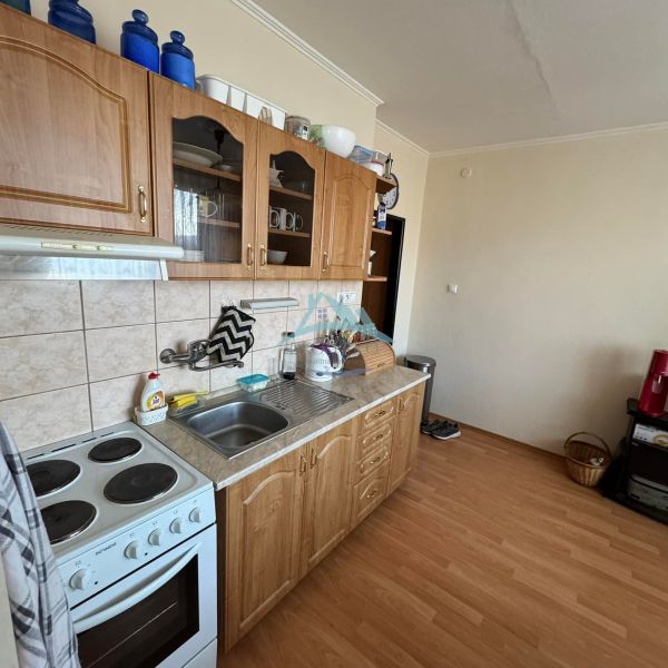 Küche in einer Einzimmerwohnung mit Holzboden und Küchenzeile.