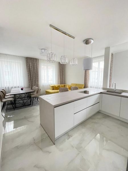 Küche in einer 3-Zimmer-Wohnung mit gelbem Sofa und Esstisch.