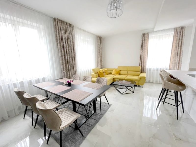 Helles Wohnzimmer mit Esstisch, gelbem Sofa und Barhockern in einer 3-Zimmer-Wohnung.