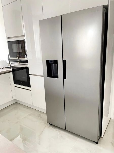 Küche in einer 3-Zimmer-Wohnung mit einem Kühlschrank aus Edelstahl und Keramikfliesen.