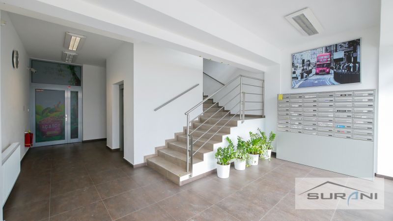 Eine Treppe mit einem Edelstahlgeländer und Briefkästen im Büro.