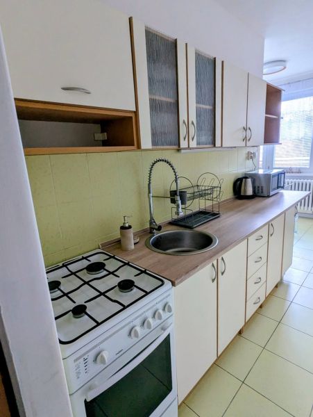 Küche in einer 2-Zimmer-Wohnung mit Herd, Spüle und Küchenzeile.