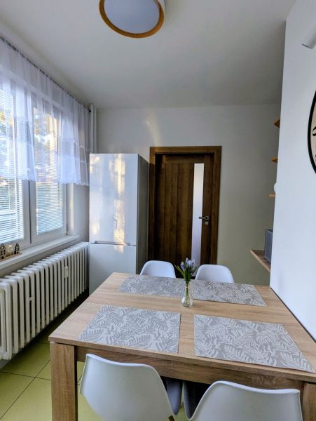 Essbereich in einer 2-Zimmer-Wohnung mit Holztisch und weißen Stühlen.