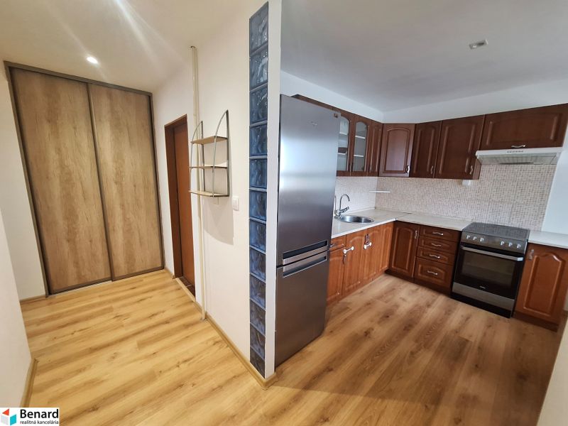 Küche in einer 2-Zimmer-Wohnung mit Holzmöbeln und Einbauschrank.