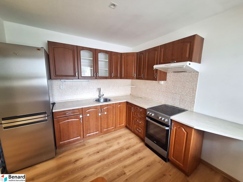 Küche in einer 2-Zimmer-Wohnung mit Holzschränken und Küchengeräten.