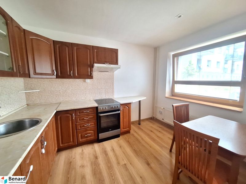 Küche in einer 2-Zimmer-Wohnung mit Einbauschränken und Esstisch.
