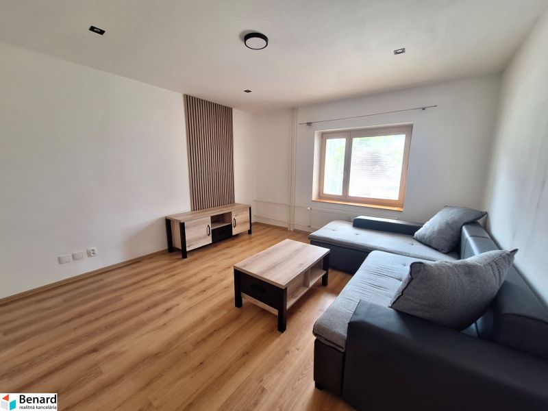 Wohnzimmer mit Ecksofa und Holzmöbeln in einer 2-Zimmer-Wohnung.