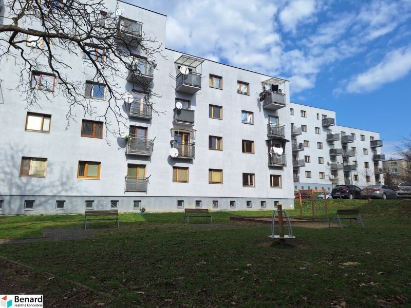 Ein Wohnhaus in der Majakovského-Straße in Prešov, umgeben von Grünflächen und einem Parkplatz.