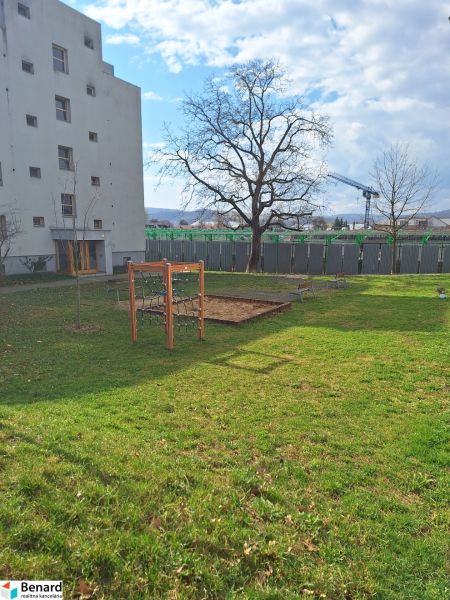 Hof bei einer 2-Zimmer-Wohnung in der Majakovského-Straße in Prešov mit Rasen und Bäumen.