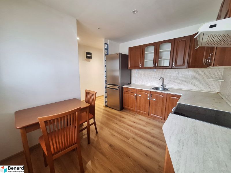 Küche mit Holzmöbeln und Geräten in einer 2-Zimmer-Wohnung.