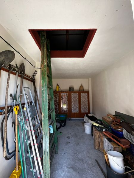 Ein Lagerraum mit Werkzeugen im Einfamilienhaus, mit Zugang zum Dachboden über eine Leiter.