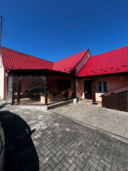 Ein Einfamilienhaus in Lakšárska Nová Ves in Mikulášov mit einem roten Dach und einem gepflasterten Hof.