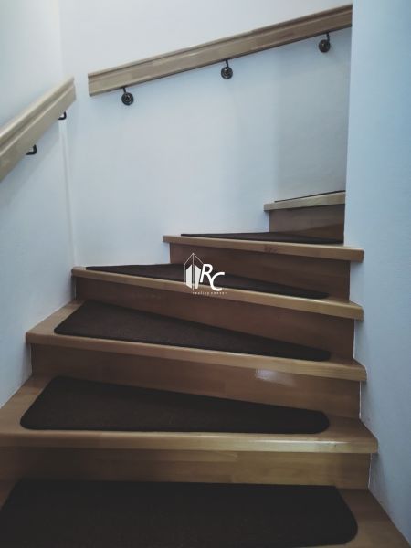 Innenraum mit Holztreppe und Geländer in einem Einfamilienhaus.