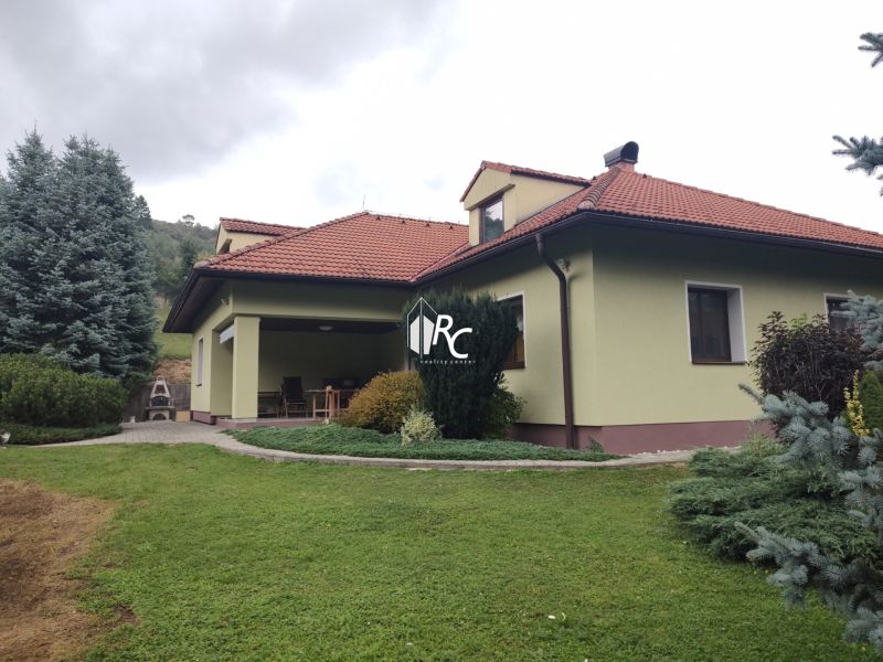 Ein Einfamilienhaus in Trebostovo mit Garten, Rasen, Terrasse und Bäumen im Hof.