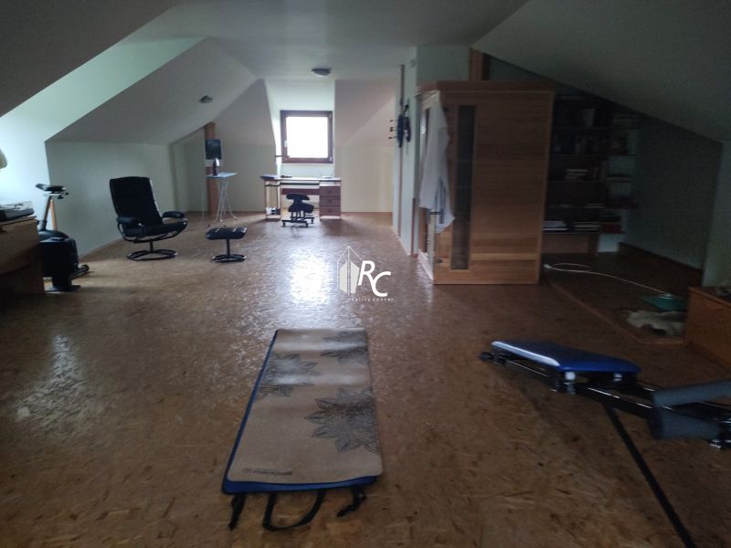 Dachbodenraum in einem Einfamilienhaus mit Holzboden und Fitnessgeräten.