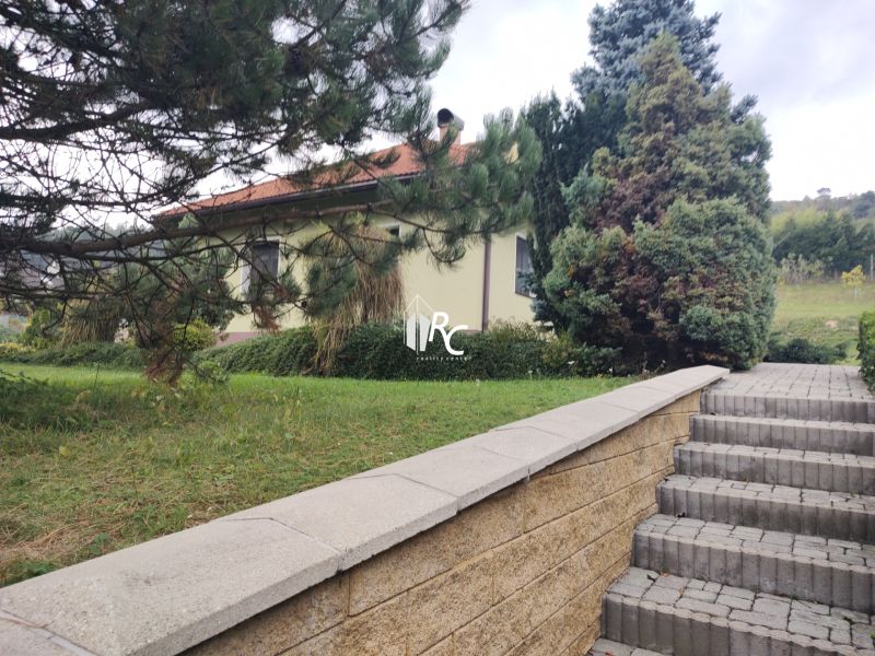 Ein Einfamilienhaus in Trebostovo mit Grünflächen und einer Treppe aus Betonblöcken.