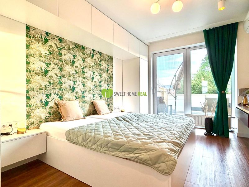 Schlafzimmer in einer 3-Zimmer-Wohnung mit Holzboden und grünem Vorhang.