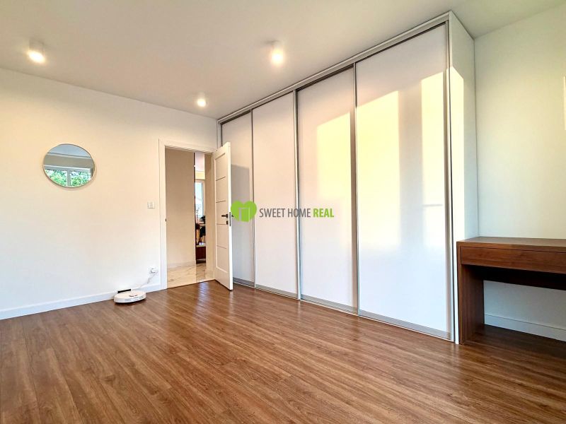 Ein Zimmer in einer 3-Zimmer-Wohnung mit einem Boden in Holzoptik, einem Einbauschrank und einem Spiegel.