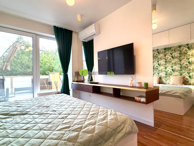 Schlafzimmer in einer 3-Zimmer-Wohnung mit großen Fenstern, grünen Vorhängen und einem Boden mit Holzdekor.